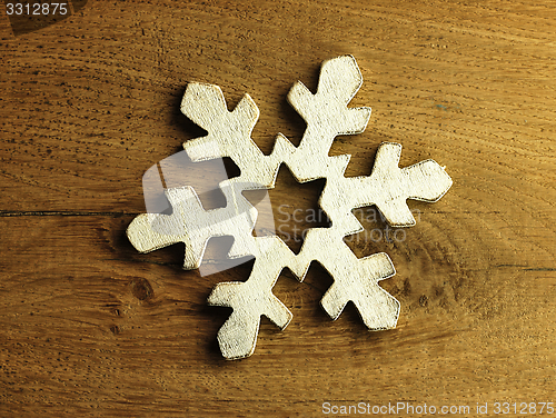 Image of Huge white snowflake and wooden background.