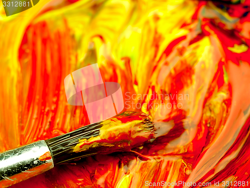 Image of Colored paint mixed on palette. Dirty brush in the foreground.