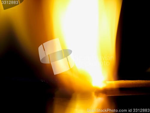 Image of Burning match on a black background.