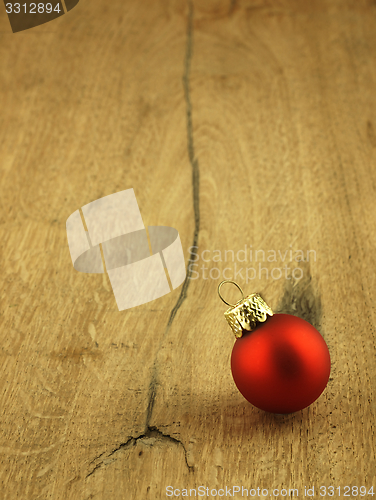 Image of Red Christmas bauble on a wooden oak background.