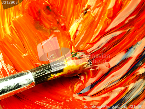 Image of Colored paint mixed on palette. Dirty brush in the foreground.