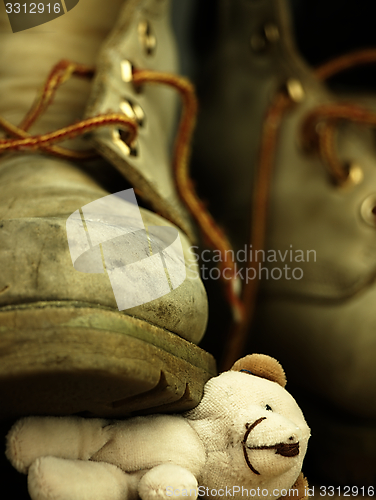 Image of Teddy bear crushed by a heavy, old military boot.