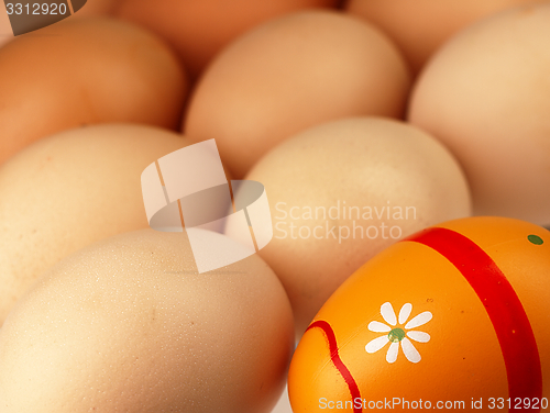 Image of Colorful Easter egg in the company of ordinary eggs.