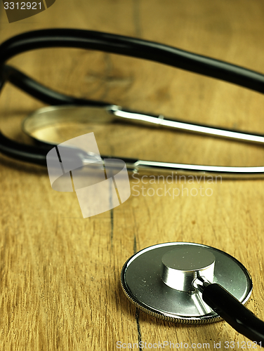 Image of Medical stethoscope on a wooden desk.