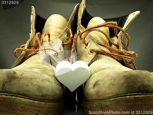 Image of Pair of heavy military boots and white heart.