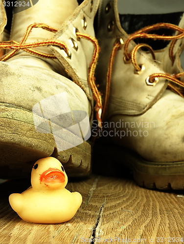 Image of Rubber duck crushed by a heavy, old military boot.