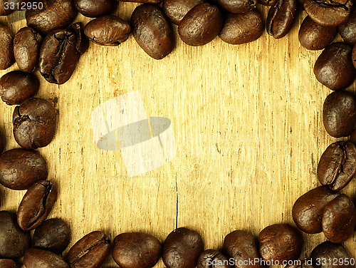 Image of Coffee beans close-up on wooden, oak table.