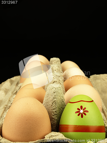 Image of Colorful Easter egg in the company of ordinary eggs.