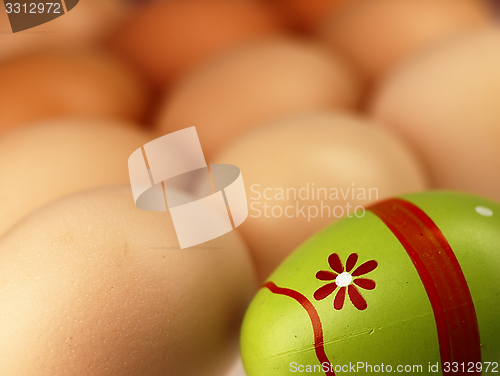 Image of Colorful Easter egg in the company of ordinary eggs.