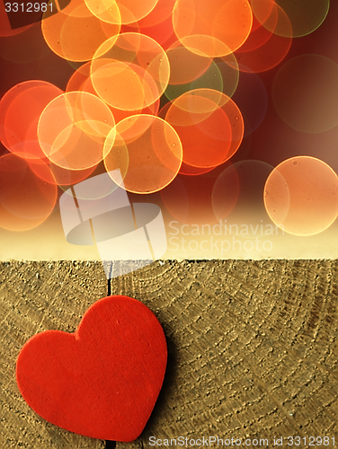Image of Red heart on the edge of a wooden table.