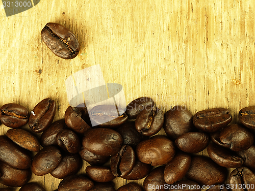 Image of Coffee beans close-up on wooden, oak table.