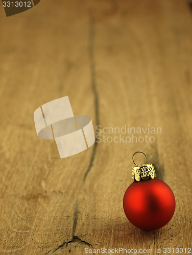 Image of Red Christmas bauble on a wooden oak background.