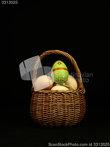 Image of Colorful Easter egg in the company of ordinary eggs.