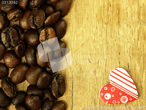 Image of Heart and Coffee beans close-up on wooden, oak table.