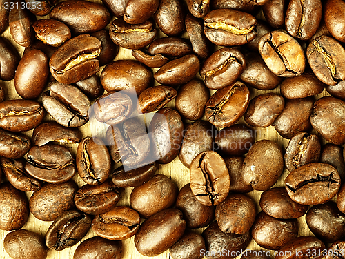 Image of Coffee beans close-up on wooden, oak table.