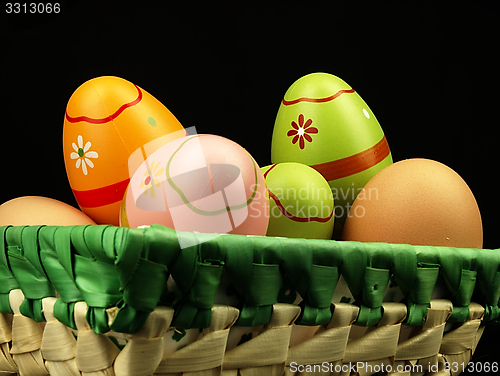 Image of Colorful Easter eggs in the company of ordinary eggs.