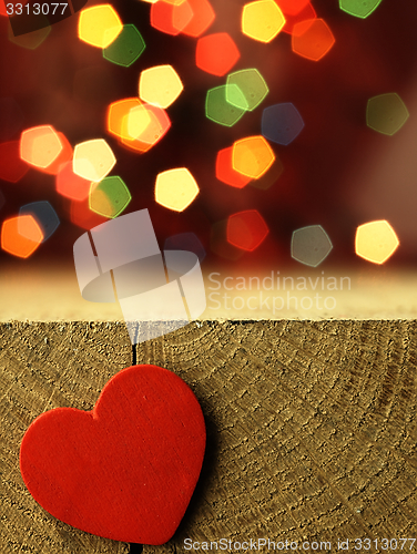 Image of Red heart on the edge of a wooden table.