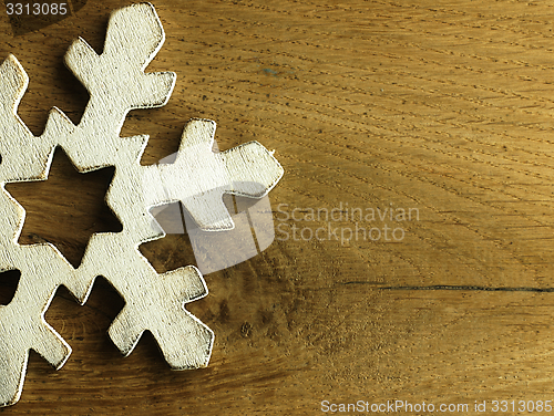 Image of Huge white snowflake and wooden background.