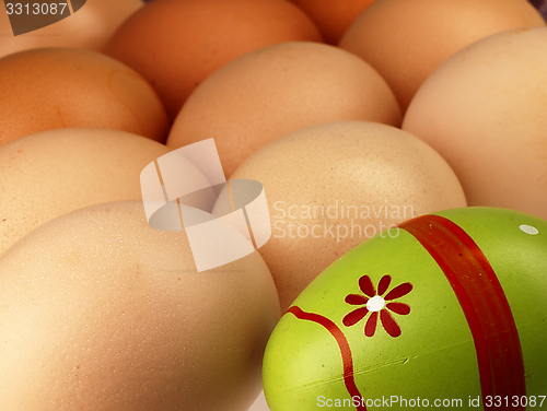 Image of Colorful Easter egg in the company of ordinary eggs.