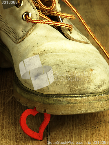 Image of Rubber duck crushed by a heavy, old military boot.