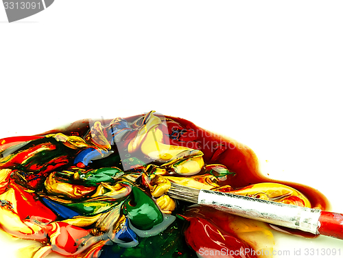 Image of Colored paint mixed on palette. Dirty brush in the foreground.