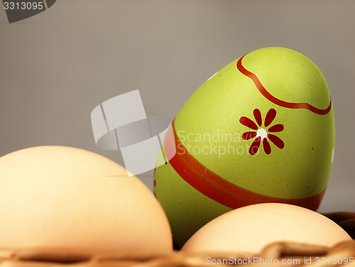 Image of Colorful Easter egg in the company of ordinary eggs.