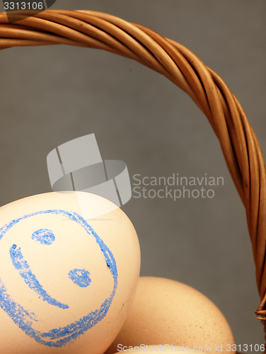 Image of Easter egg with a happy face in the basket.