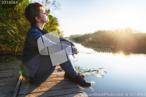 Image of Woman relaxing on jetty