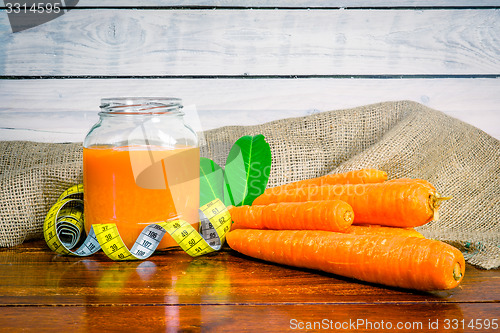 Image of Carrot juice on a table with measure tape