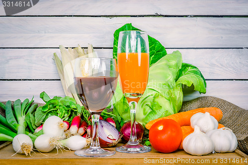 Image of Vegetables on a wooden table with juice