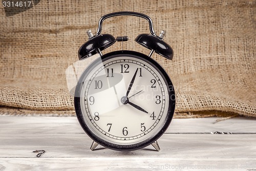 Image of Classic alarm clock on a wooden table