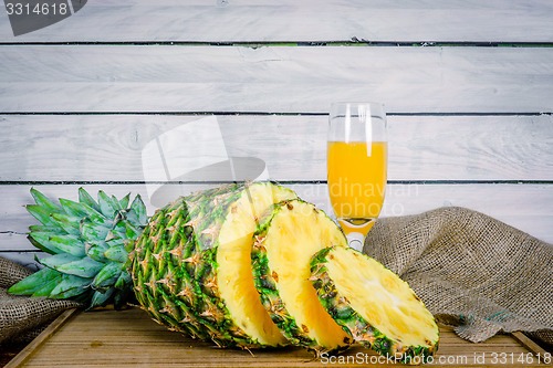 Image of Pineapple and juice on a wooden board