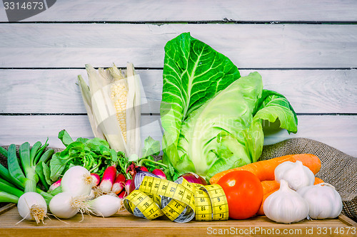 Image of Vegetables on a wooden table with measure tape