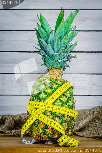 Image of Pineapple with measure tape on a table