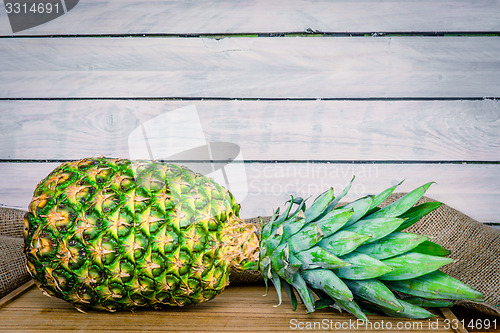 Image of Pineapple on a wooden table with linen