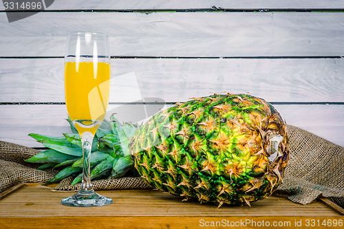 Image of Pineapple and juice on a wooden table