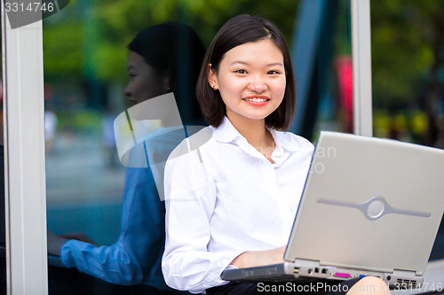 Image of Young Asian female executive using laptop PC