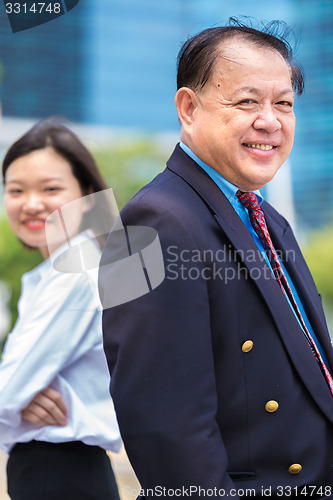 Image of Young Asian female executive and senior businessman in suit portrait