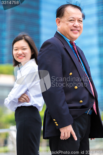 Image of Young Asian female executive and senior businessman in suit portrait