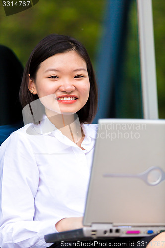 Image of Young Asian female executive using laptop PC