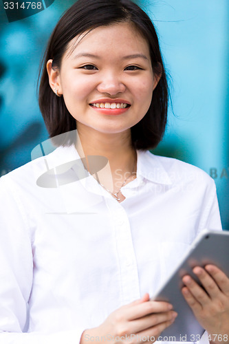 Image of Young Asian female executive using tablet PC