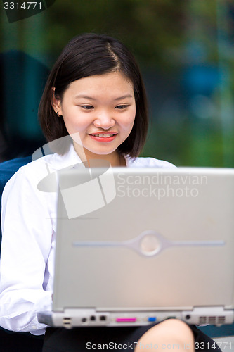 Image of Young Asian female executive using laptop PC