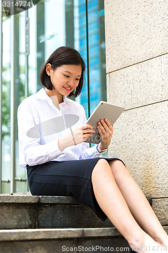 Image of Young Asian female executive using tablet PC