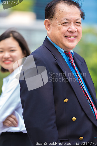 Image of Young Asian female executive and senior businessman in suit portrait