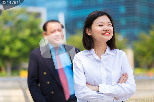 Image of Young Asian female executive and senior businessman in suit portrait