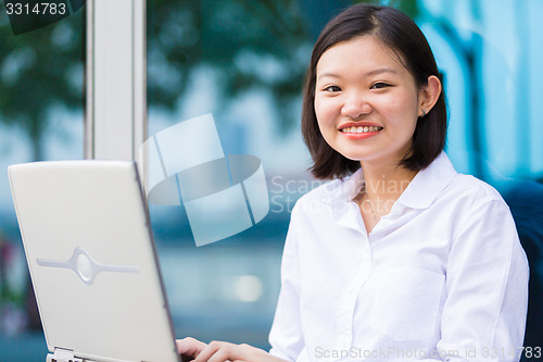 Image of Young Asian female executive using laptop PC