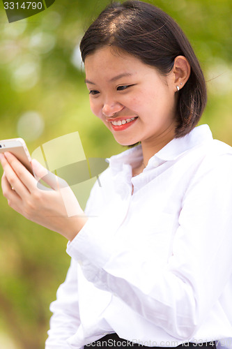 Image of Young Asian female executive using smart phone