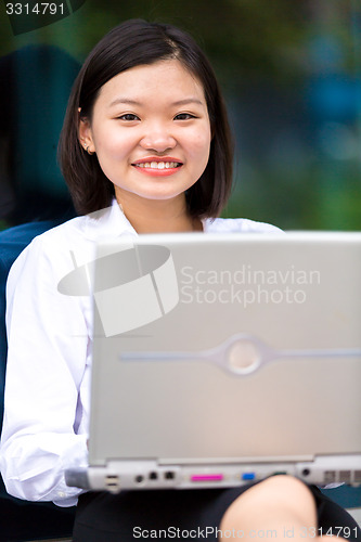 Image of Young Asian female executive using laptop PC