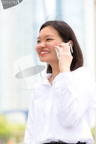 Image of Young Asian female executive using smart phone