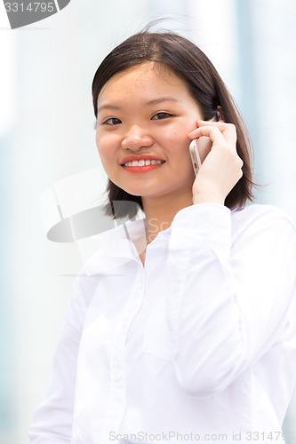 Image of Young Asian female executive using smart phone